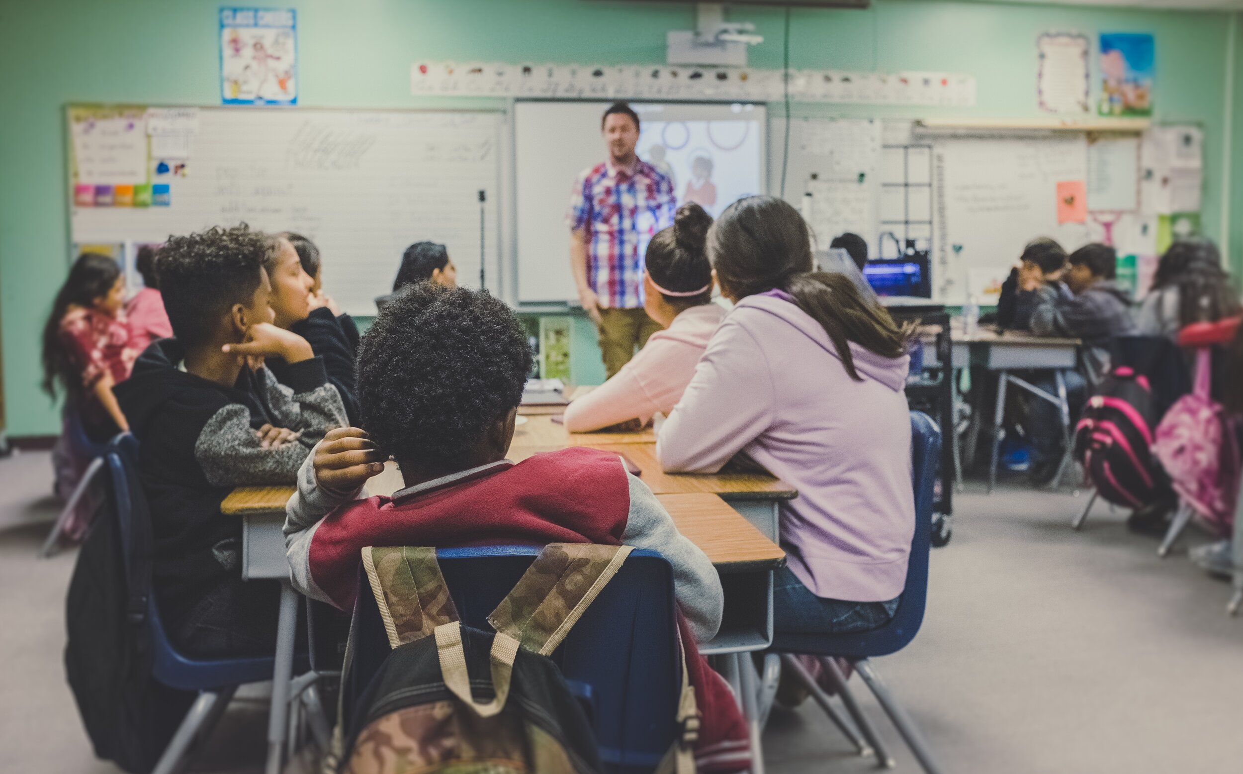 Students seated in a classroom while a presenter speaks at the front